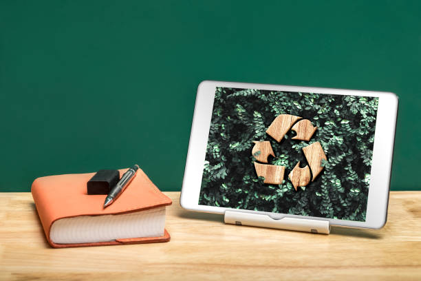 утилизировать знак на зеленом листе на планшете приложение на офисном столе с книгой и карандашом. концепция экологической системы окружа� - digital tablet growth note pad business стоковые фото и изображения