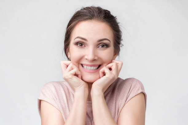 istock Happy beautiful girl holding her cheeks with a laugh looking at camera. 1130670415