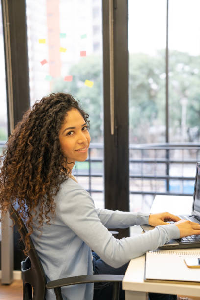 istock Smiling business woman at work typing on laptop 1130670774