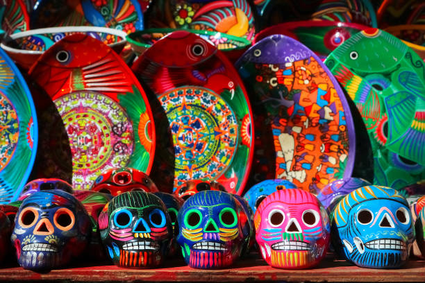 istock Traditional Mexican souvenirs. Multi-colored ceramic skulls and tableware in the gift shop. Symbol of the day of the dead. Selective focus. 1130672068