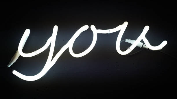 istock Glowing neon sign on the wall. Word 'you' shape 1130673544