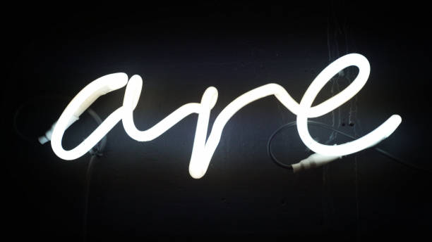 istock Glowing neon sign on the wall. Word 'are' shape 1130673713