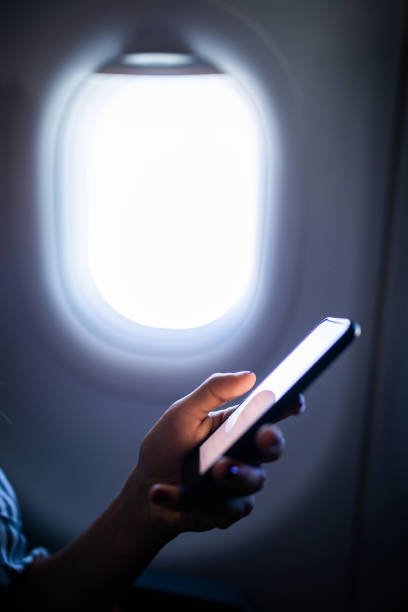 istock Close up of unrecognizable person using cell phone in a plane. 1130674173