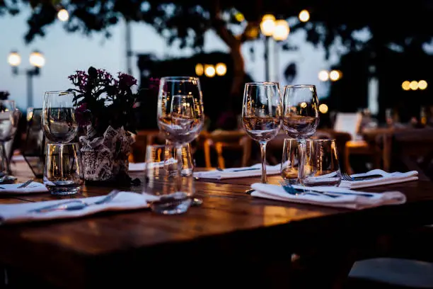 Photo of Luxury table settings for fine dining with and glassware, beautiful blurred  background. For events, weddings.