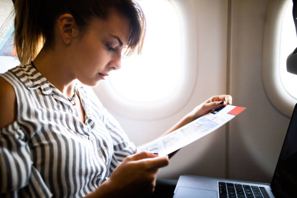 istock Young woman reading while traveling by plane. 1130675022