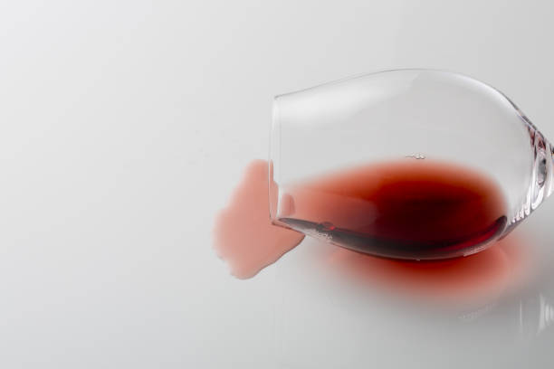 istock Spilled red wine out of glass on white background 1130675247