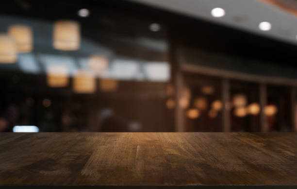 table en bois sombre vide devant fond abstrait bokeh floue du restaurant. peut être utilisé pour l’affichage ou le montage de vos produits. maquette pour l’espace. - surface aquatique photos et images de collection