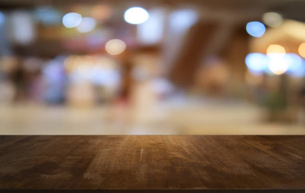 레스토랑의 추상 흐리게 bokeh 배경 앞 빈 어두운 나무 테이블. 디스플레이에 사용할 수 있습니다 또는 귀하의 제품을 몽타주. 공간에 대 한 조롱. - water surface 뉴스 사진 이미지