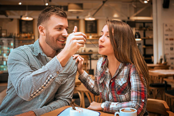 istock Couple eating with spoon cake feeding each other and smiling 1130676759