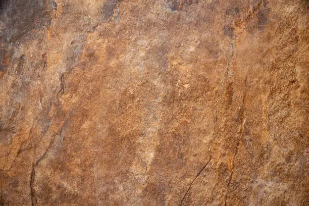 Photo of Textured surface of the marble rock with brown tint background