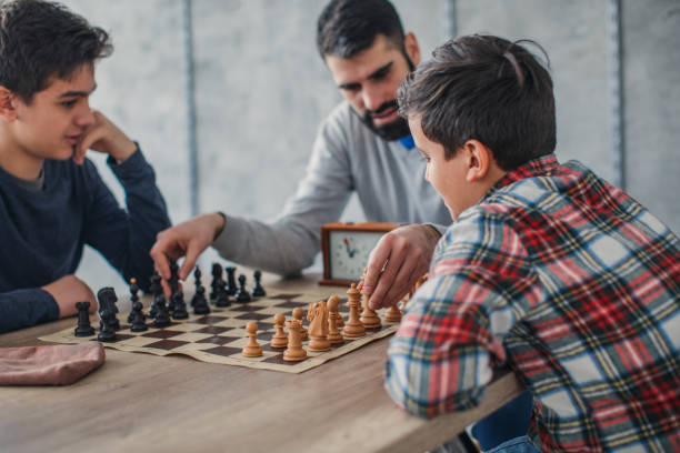 istock Two boys and chess teacher playing chess 1130678966
