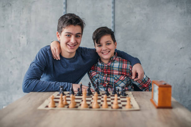 Two smart boys in chess school Two young boys, playing chess in school of chess. chess timer stock pictures, royalty-free photos & images