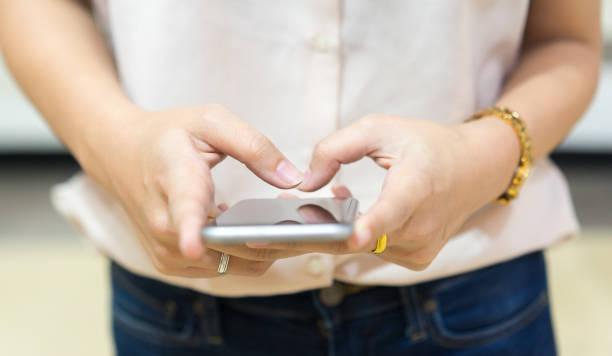 istock close up young woman holding smartphone and typing on screen device for reply online chat or surf the internet or playing mobile application , technology lifestyle concept 1130682988