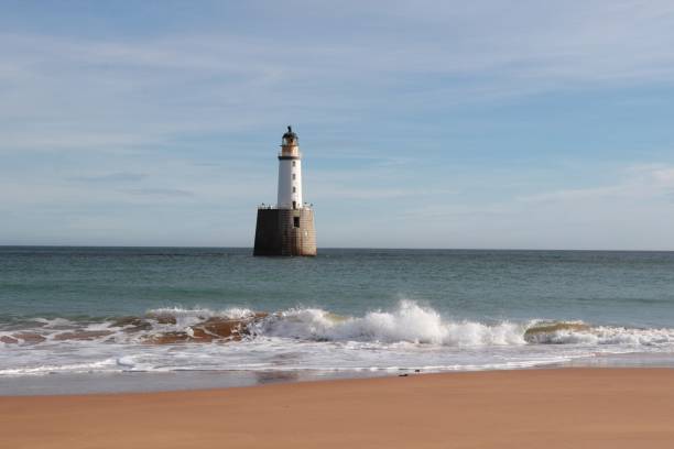 istock Seascape with white lighthouse on stone platform in sea 1130683156
