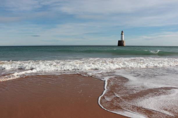 istock Seascape with white lighthouse on stone platform in sea 1130683176