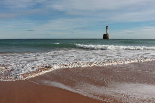 istock Seascape with white lighthouse on stone platform in sea 1130683178