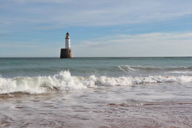 istock Seascape with white lighthouse on stone platform in sea 1130683193