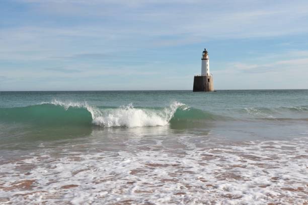 istock Seascape with white lighthouse on stone platform in sea 1130683203