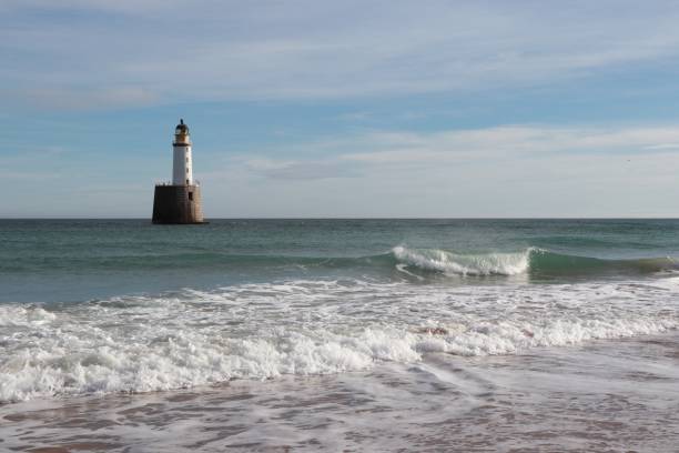 istock Seascape with white lighthouse on stone platform in sea 1130683242