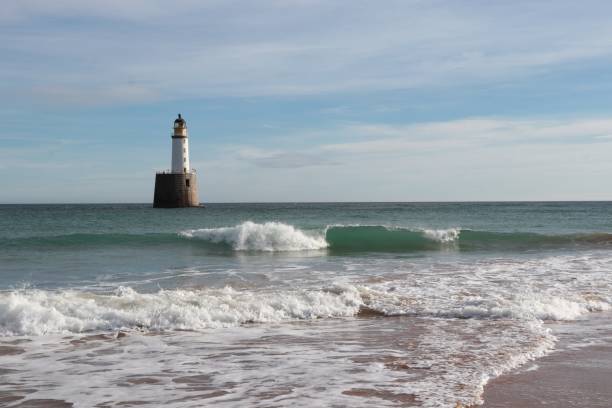 istock Seascape with white lighthouse on stone platform in sea 1130683244