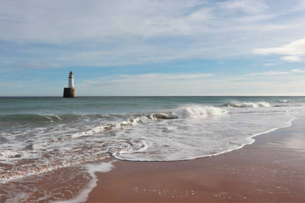 istock Seascape with white lighthouse on stone platform in sea 1130683246