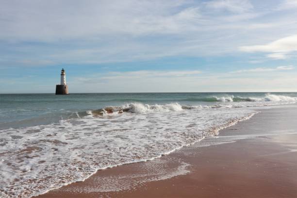 istock Seascape with white lighthouse on stone platform in sea 1130683258