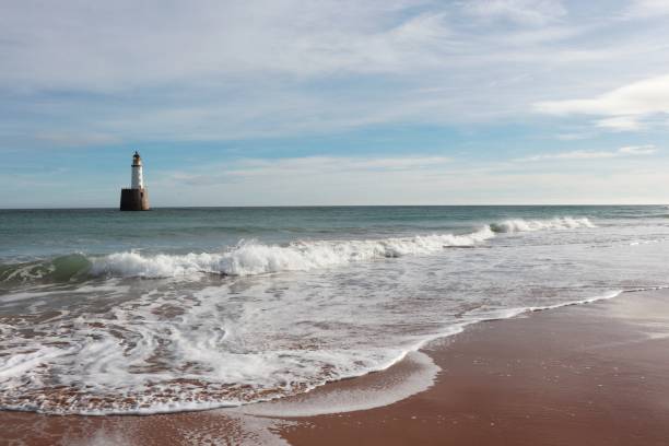 istock Seascape with white lighthouse on stone platform in sea 1130683260