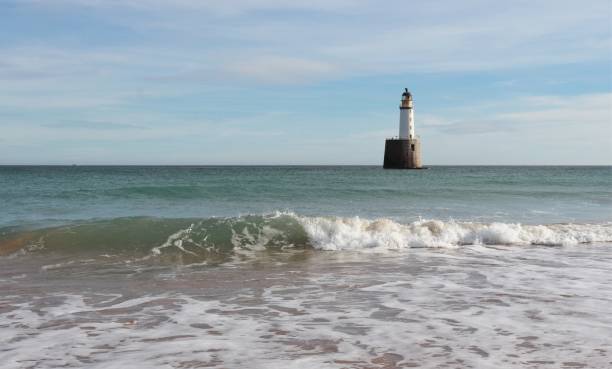 istock Seascape with white lighthouse on stone platform in sea 1130683262