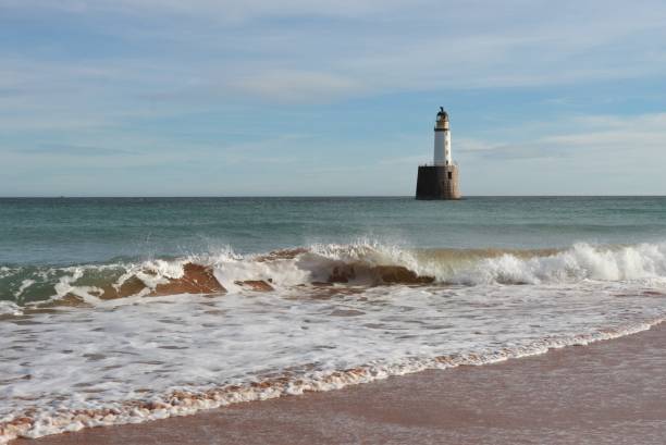istock Seascape with white lighthouse on stone platform in sea 1130683267