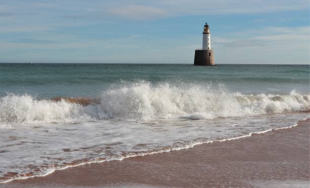 istock Seascape with white lighthouse on stone platform in sea 1130683268