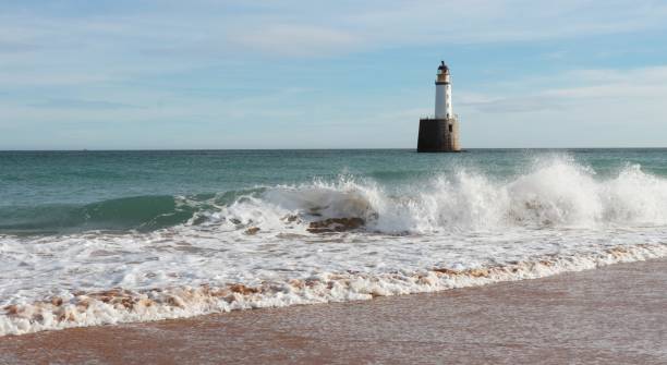 istock Seascape with white lighthouse on stone platform in sea 1130683275
