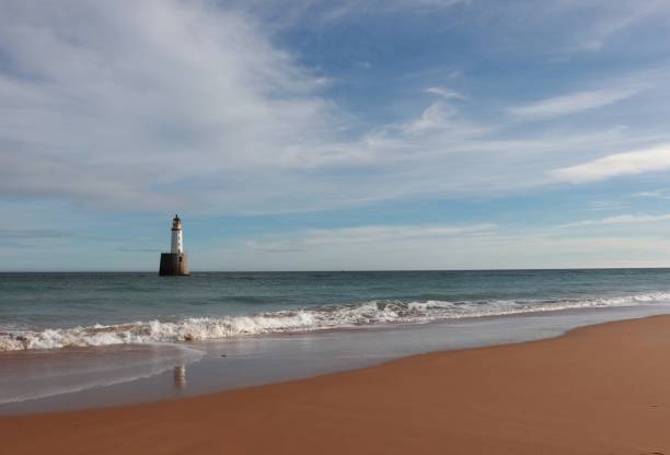 istock Seascape with white lighthouse on stone platform in sea 1130683321