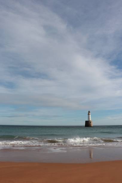 istock Seascape with white lighthouse on stone platform in sea 1130683324
