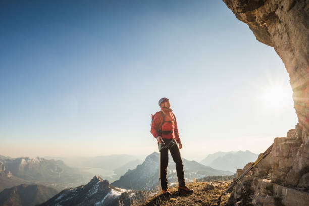 istock Alpinist looking at mountain wall 1130683522