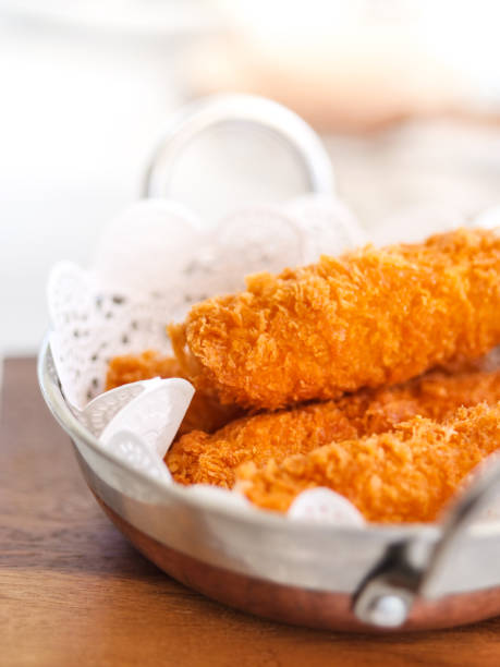 istock Fried cheese sticks in aluminium pan on wooden table, ready to eat. 1130684328