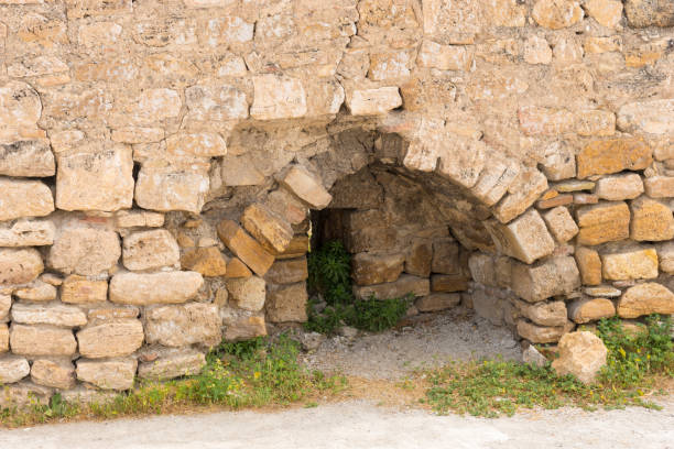 Arched entrance in an ancient stone wall in a Greek ruin in a close up view