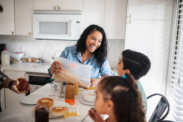 istock Hispanic mother pouring cereal in the bowl for her son 1130684873