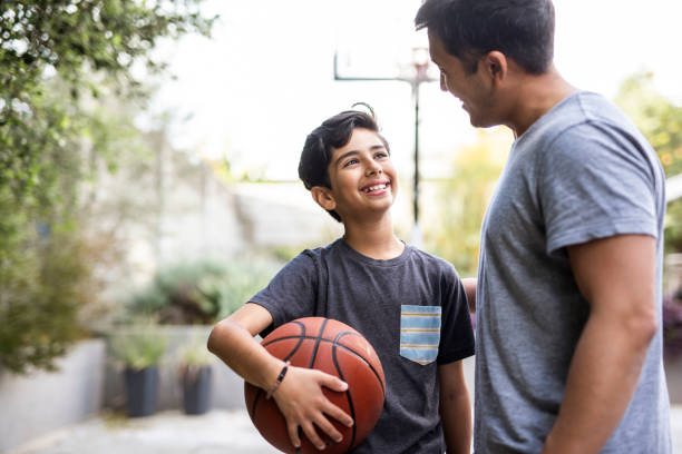 istock Father and soon standing outside with a basketball 1130685979