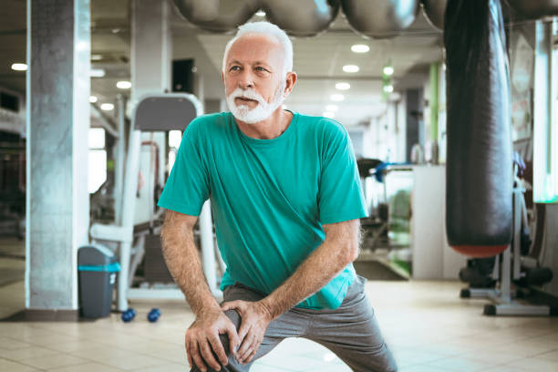 Senior man stretching in a gym