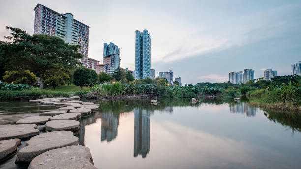 Small stream with rapid flowing water by and tall housing estate in the background. An example of co-existence of urban living with nature