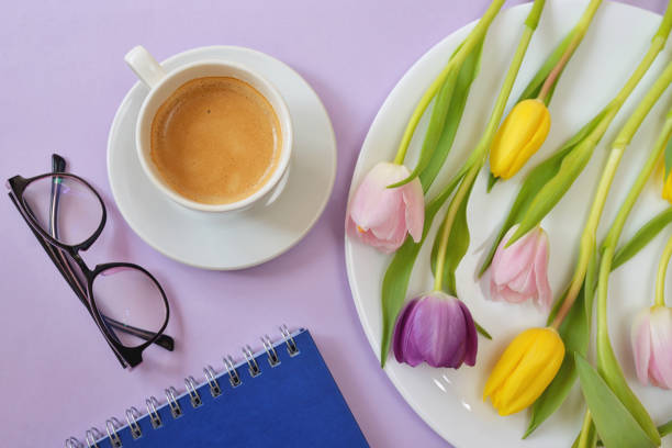 istock Cup of coffee and tulips on spring table 1130687686