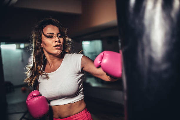 istock Beautiful woman boxer punching a punching bag 1130688537