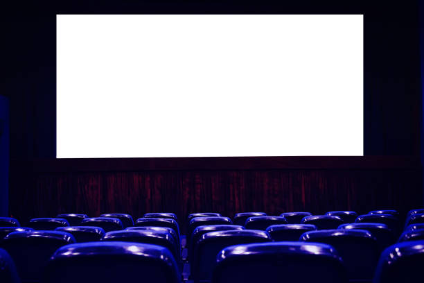 istock Empty cinema auditorium with empty white screen. Empty rows of theater or movie seats. Blue toned. 1130688715