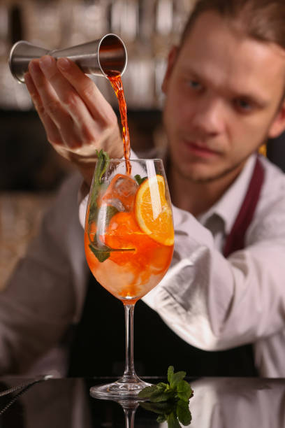 istock Barmen is making Spritz cocktail. Alcohol cocktail on black background surface 1130688723