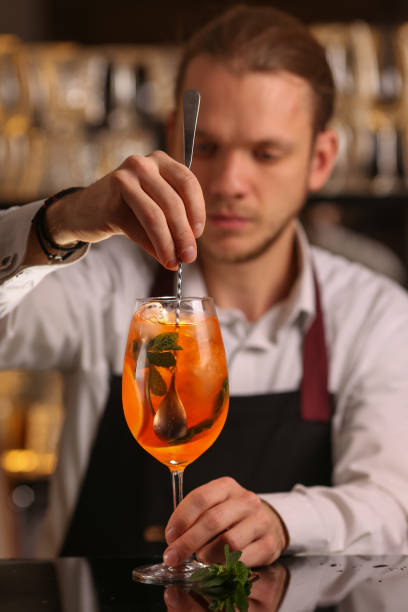 istock Barmen is making Spritz cocktail. Alcohol cocktail on black background surface 1130688734