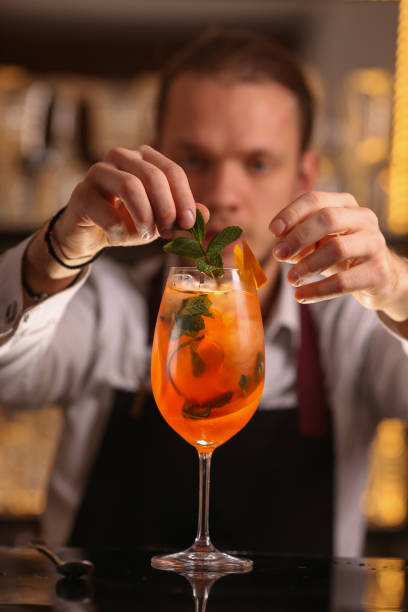 istock Barmen is making Spritz cocktail. Alcohol cocktail on black background surface 1130688746