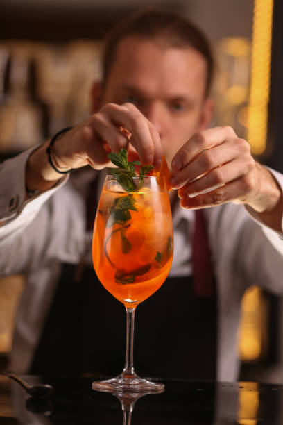 istock Barmen is making Spritz cocktail. Alcohol cocktail on black background surface 1130688780