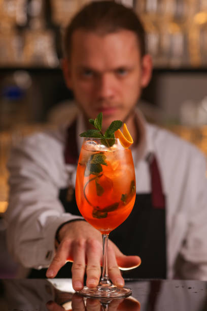 istock Barmen is making Spritz cocktail. Alcohol cocktail on black background surface 1130688847