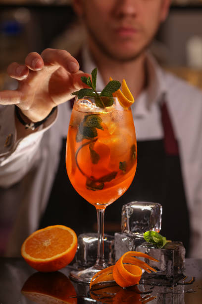 istock Barmen is making Spritz cocktail. Alcohol cocktail on black background surface 1130688912