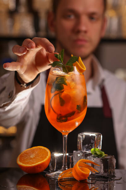 istock Barmen is making Spritz cocktail. Alcohol cocktail on black background surface 1130688921